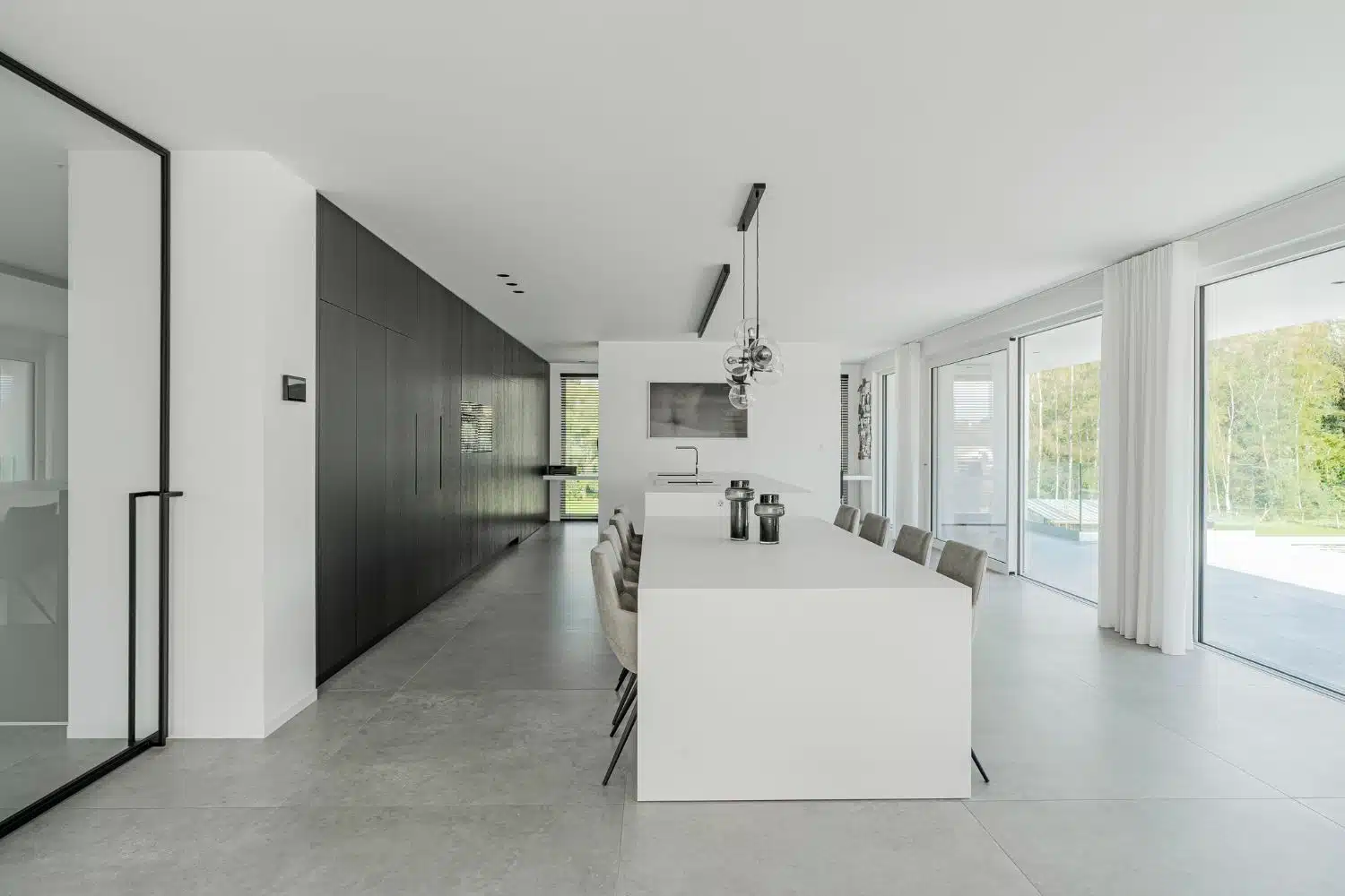 Interieurarchitect Peter Roekens zorgde voor de interieurinrichting van deze nieuwbouw. lichtrijke keuken - grijze keuken - grijs interieur - grijze stoelen - veel licht - licht keuken - witte keuken - wit interieur