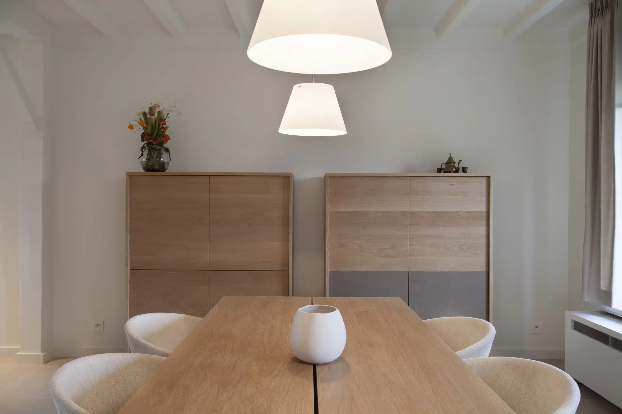 Eethoek met eikenhouten dressoirs en design hanglampen